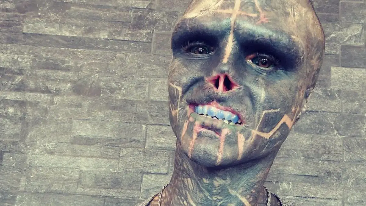 Alien-Mensch ritzt sich Schriftzug in den Kopf