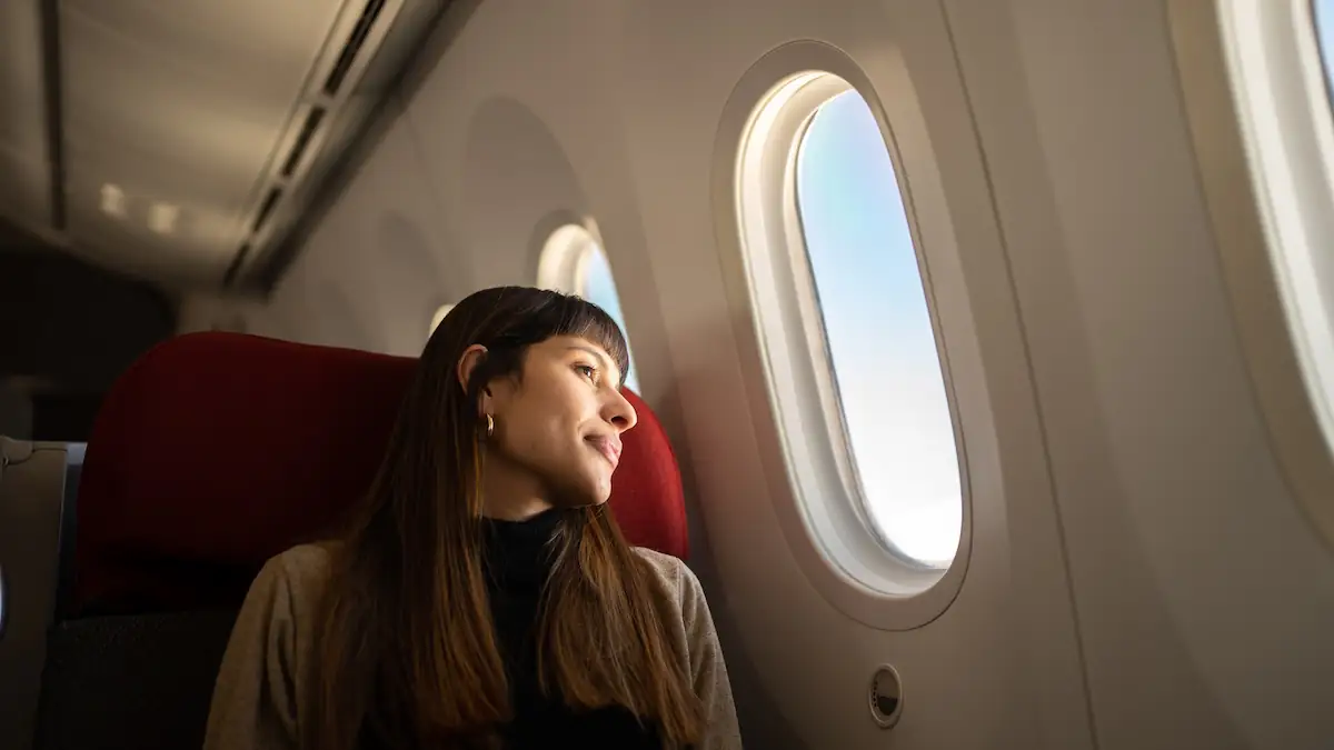 Junge rau schaut aus Flugzeugfenster