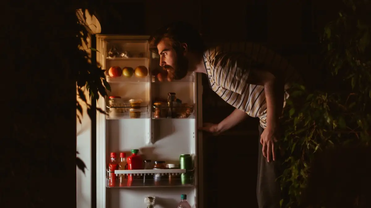 Mann sucht nachts im Kühlschrank nach etwas zu essen