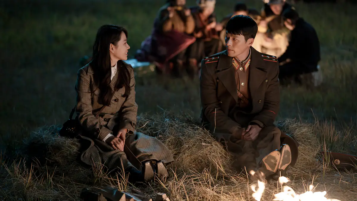 Szene aus Crush Landing On You: Yoon Se-ri	und Ri Jeong-hyeok sitzen am Lagerfeuer