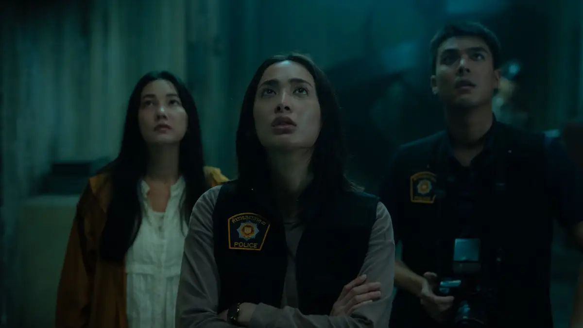 „Don't Come Home“: Szene aus Netflix-Serie, in der drei Personen in düsterer Atmosphäre nebeneinander stehen