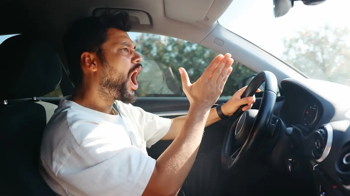 Mann schreit bei Hitze ärgerlich im Auto