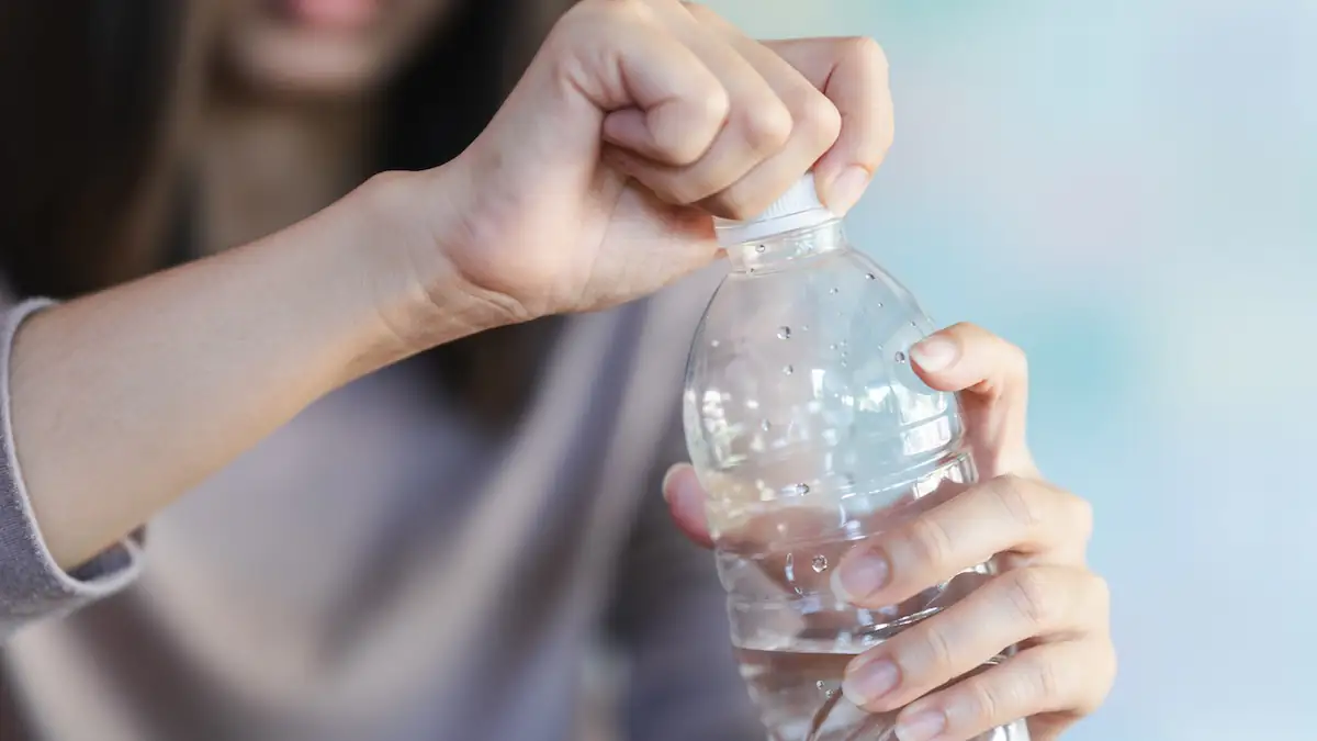 Frau öffnet Wasserflasche