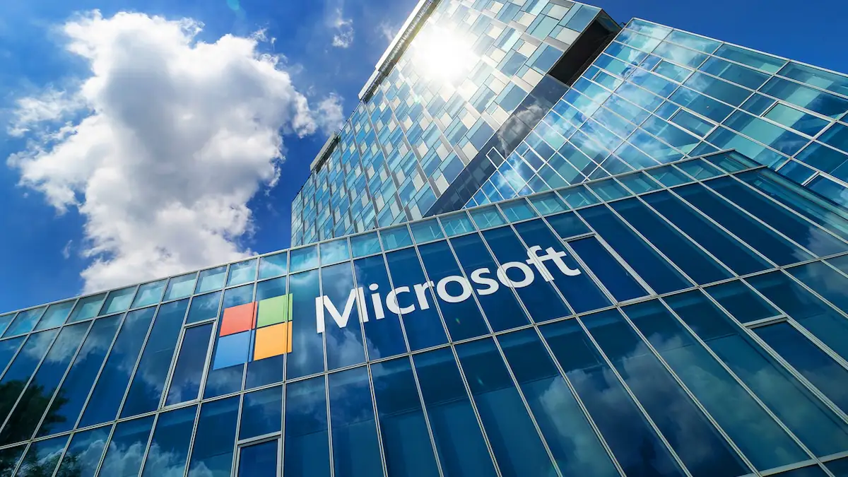 Microsoft legt Studie zu Jobs mit KI vor: Microsoft-Logo an Glaswand vor blauem Himmel