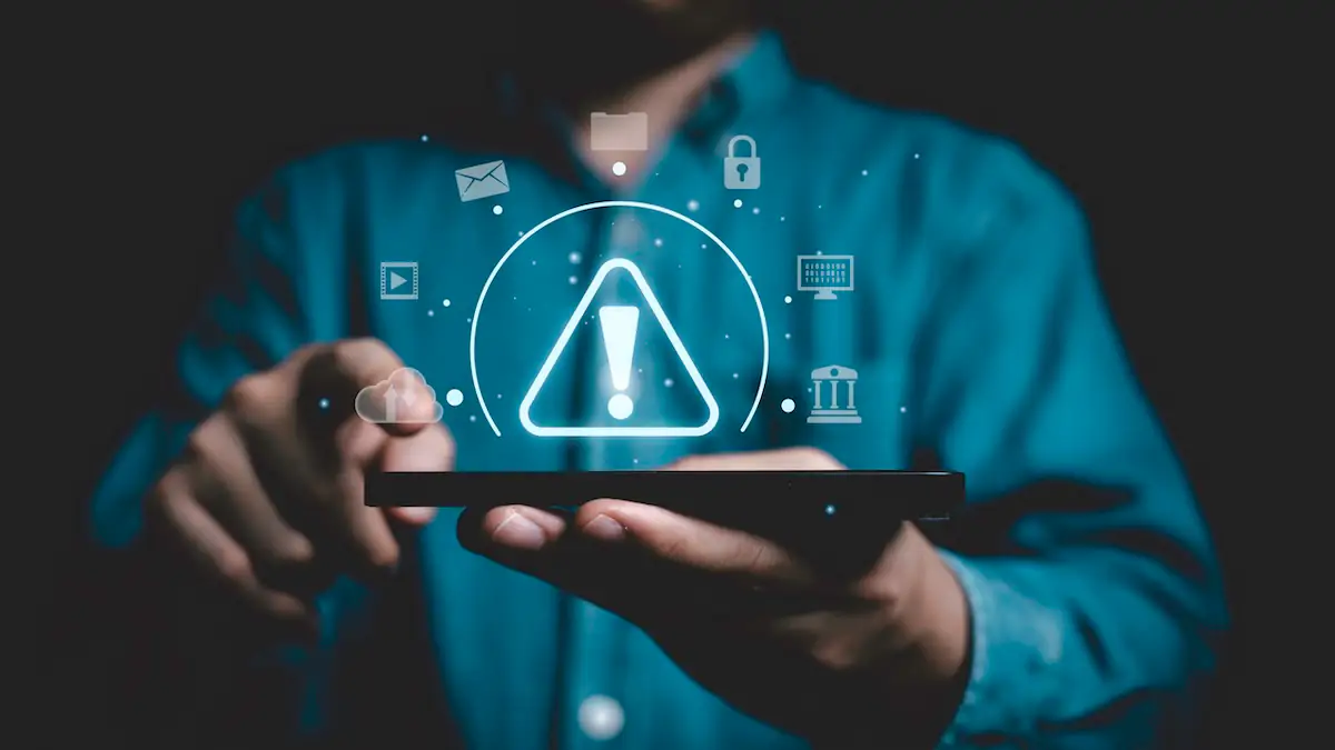 Sicherheitslücke WhatsApp Symbolbild: Warnzeichen über erleuchtetem Bildschirm im Dunkeln