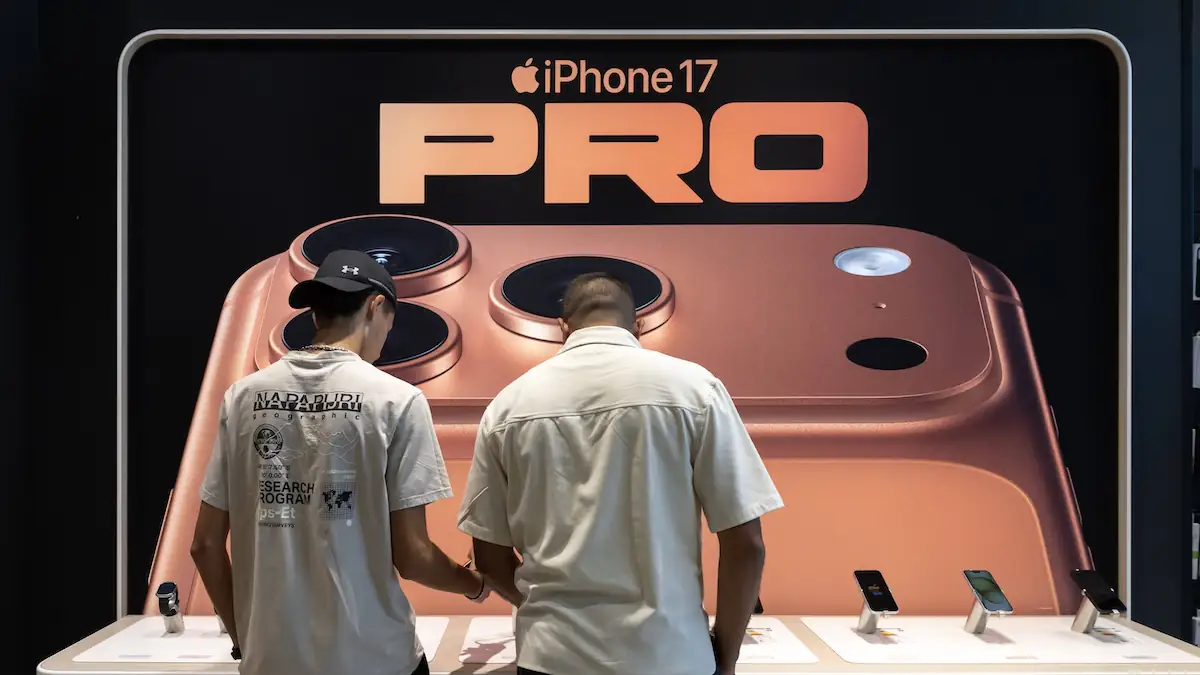 iPhone 17 Pro im Apple Store unter einem Schriftzug und Foto des Geräts, vor dem zwei Männer stehen