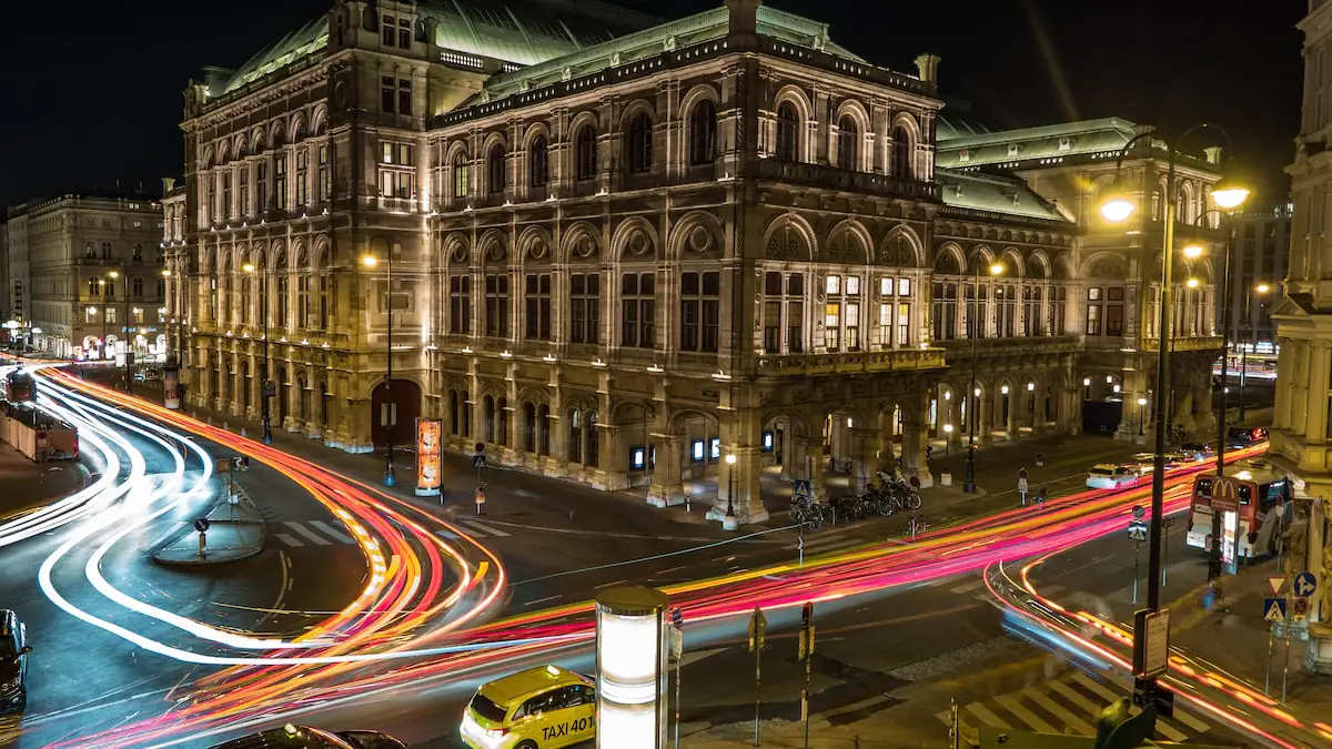 Wiener Staatsoper mit Lichtspuren vom Straßenverkehr bei Nacht, Österreich