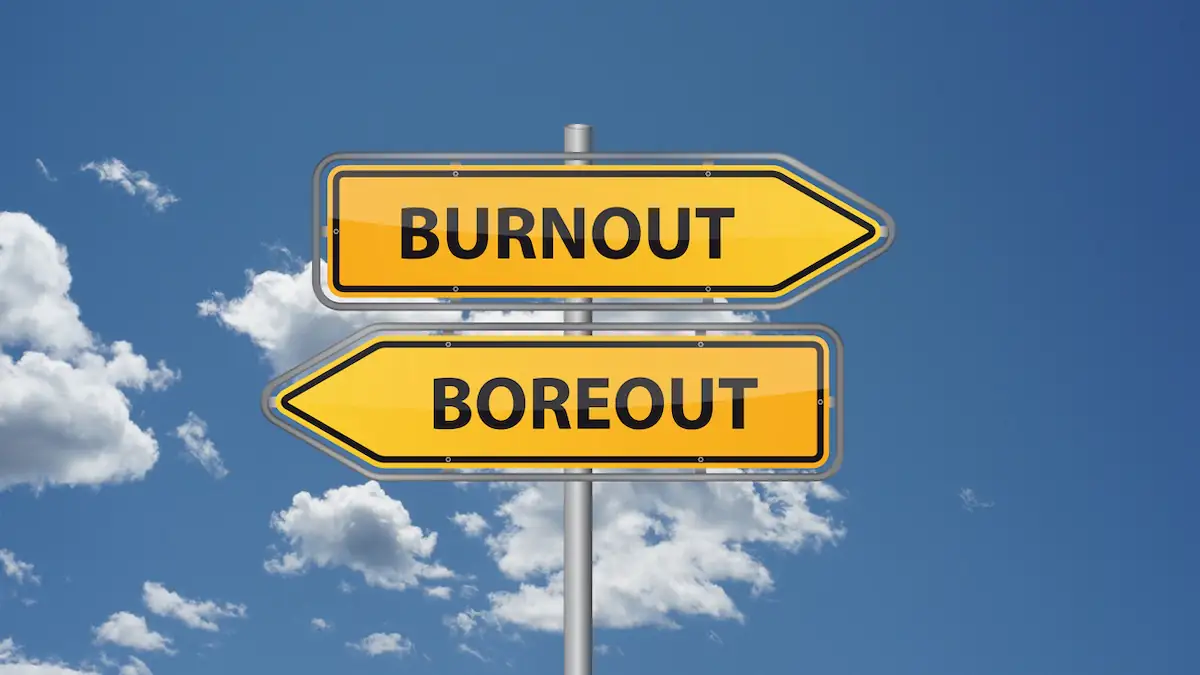 Zwei Schilder vor blauem Himmel, der Pfeil nach rechts zeigt „Burnout“, der Pfeil nach links „Boreout“