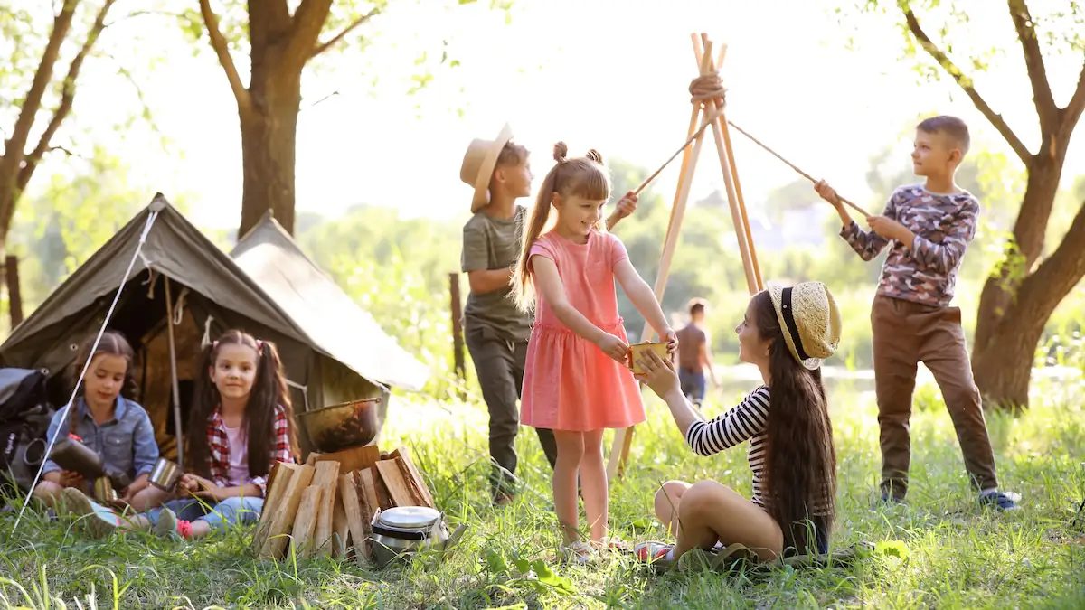 Adults only Campingplatz: Kinder spielen im Freien neben einem Zelt