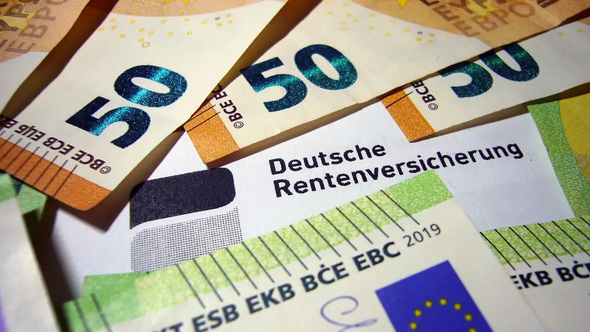 Rentenbescheid der Deutschen Rentenversicherung liegt zwischen Euroscheinen