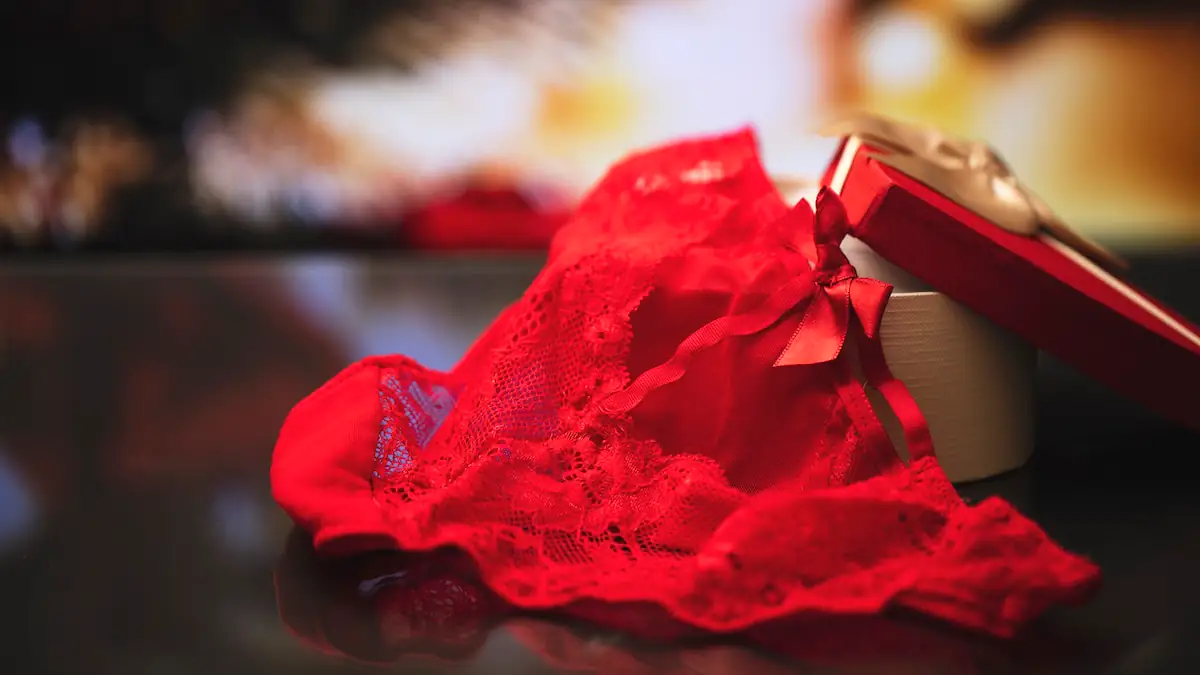 Rote Unterwäsche liegt vor einer Geschenkschachtel