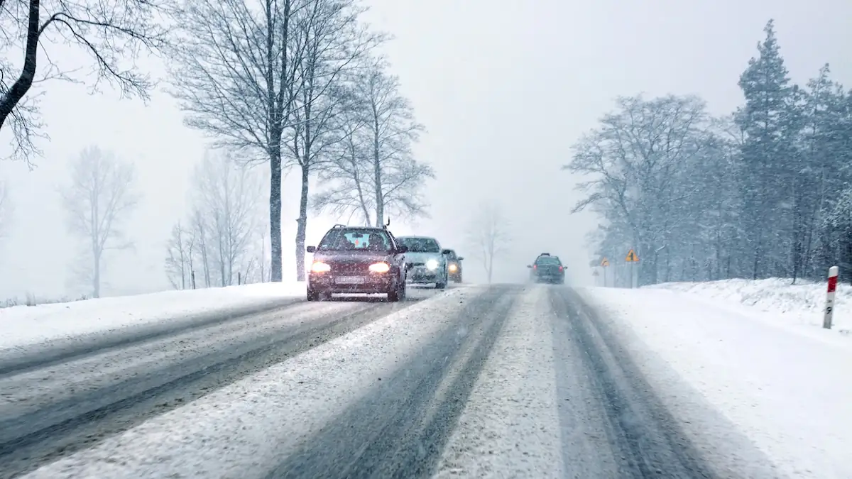 Winterreifen: Verschneite Straße, auf der Autos fahren
