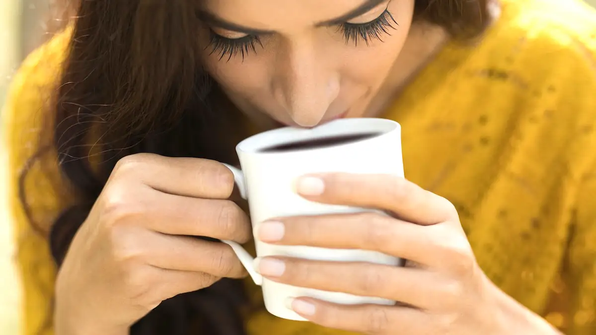 Frau trinkt eine Tasse schwarzen Kaffee