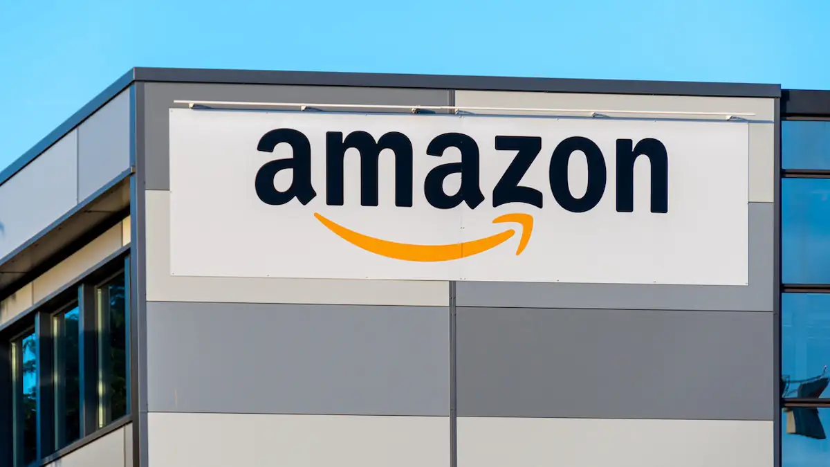 Amazon-Schriftzug und Logo an einem Gebäude vor blauem Himmel