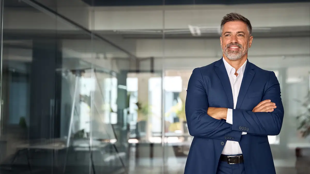 Älterer Businessmann im Anzug mit verschränkten Armen