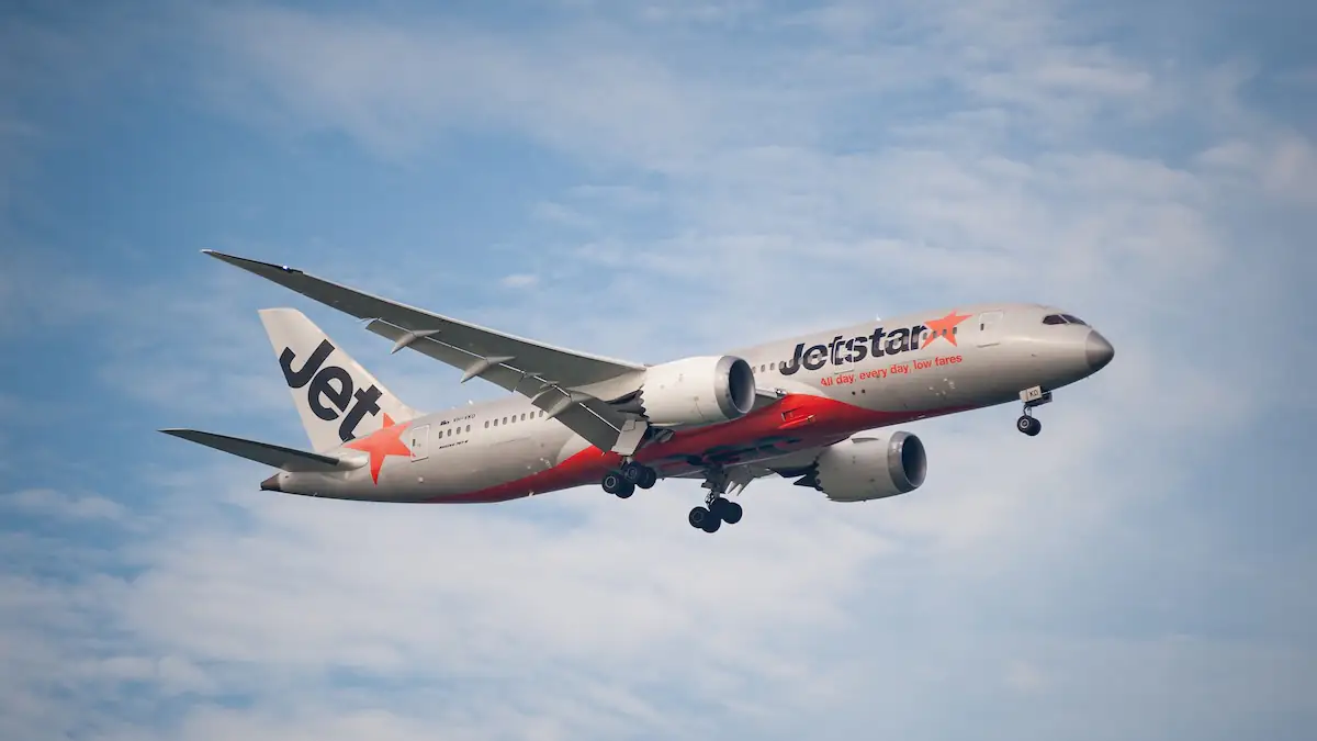 Flugzeug von Jetstar Asia in der Luft vor blauem Himmel