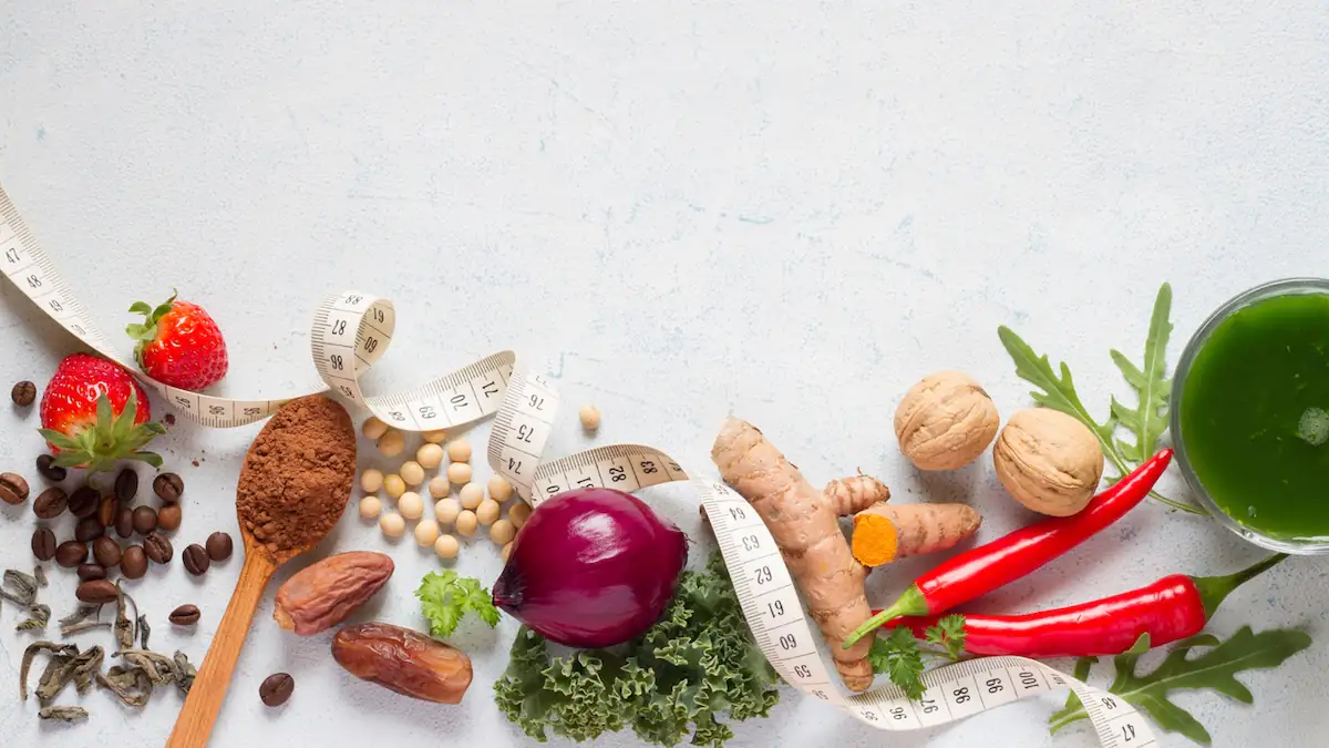 Sirt Diät: Ausgewählte Lebensmittel wie Zwiebel und Ingwer mit hohem Sirtuin-Aktivatoren mit Maßband auf leichtem Hintergrund