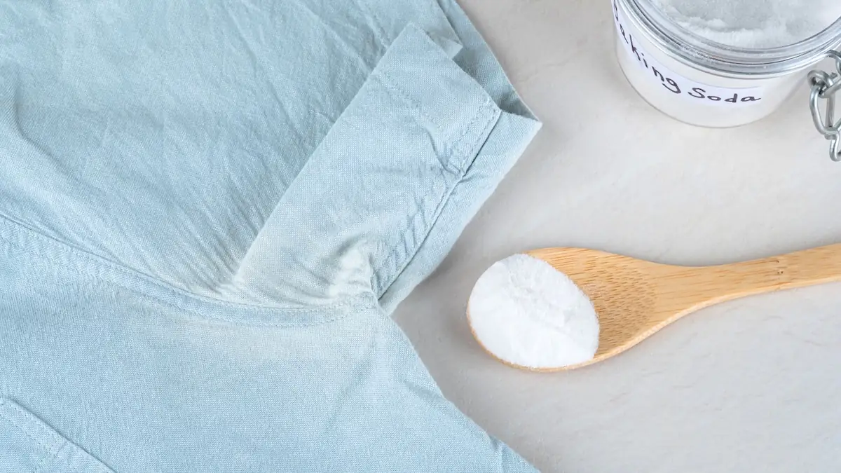 blaues Hemd mit Schweißflecken unter dem Arm, daneben ein Glas und ein Löffel mit Backpulver