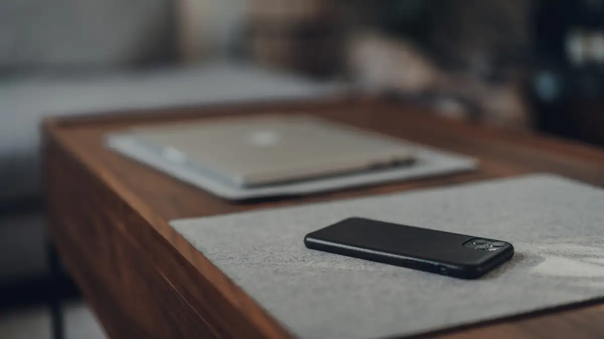 iPhone liegt umgedreht auf dem Tisch neben Macbook