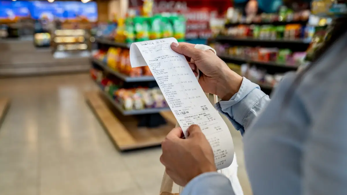 Frau betrachtet Kassenzettel beim Einkaufen