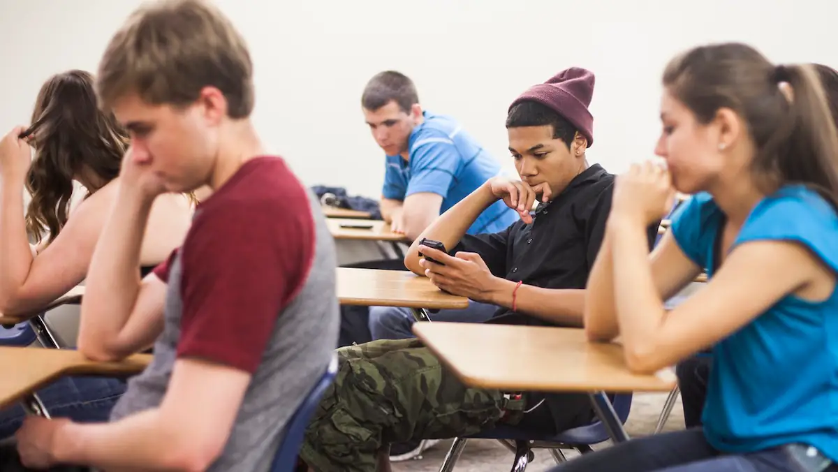 Handy-Verbot an Schulen: Schülerinnen und Schüler sitzen im Unterricht mit Smartphone da