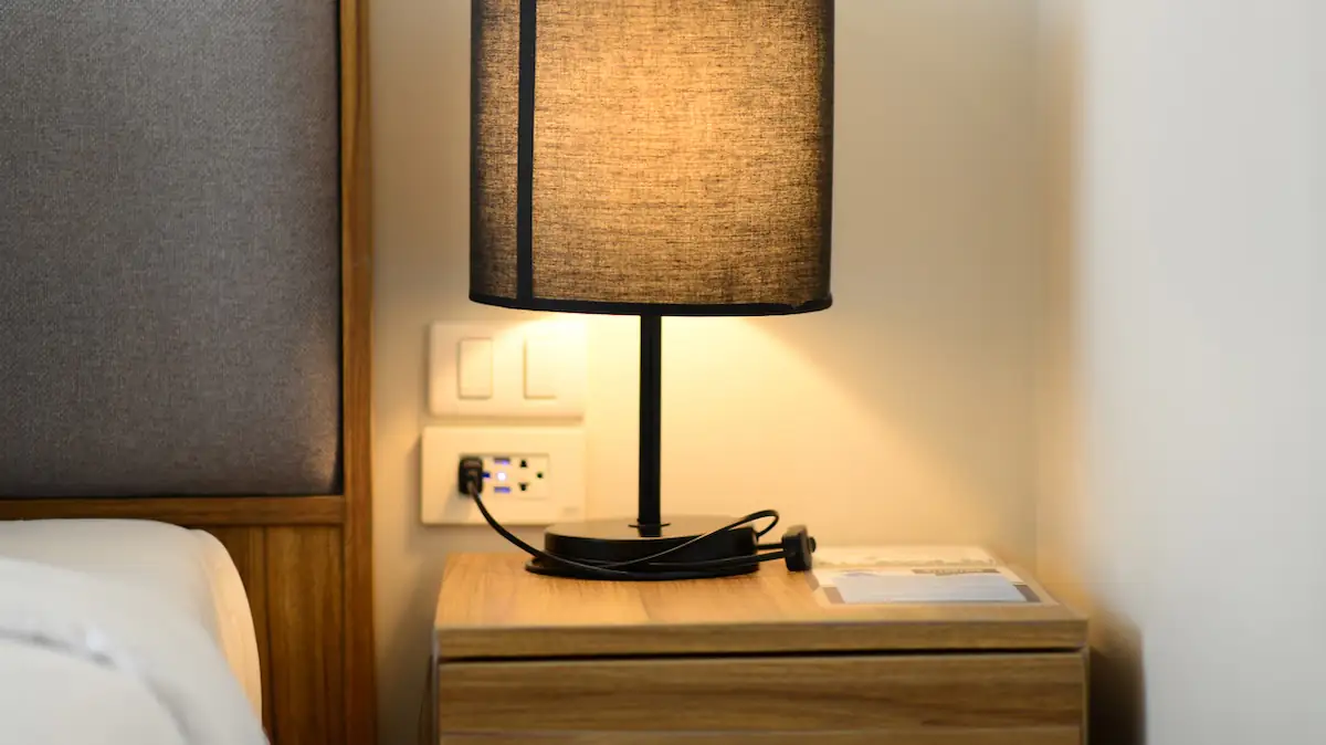 Keime Hotel: Nachttisch mit Lampe und Kabeln in einem Hotelzimmer