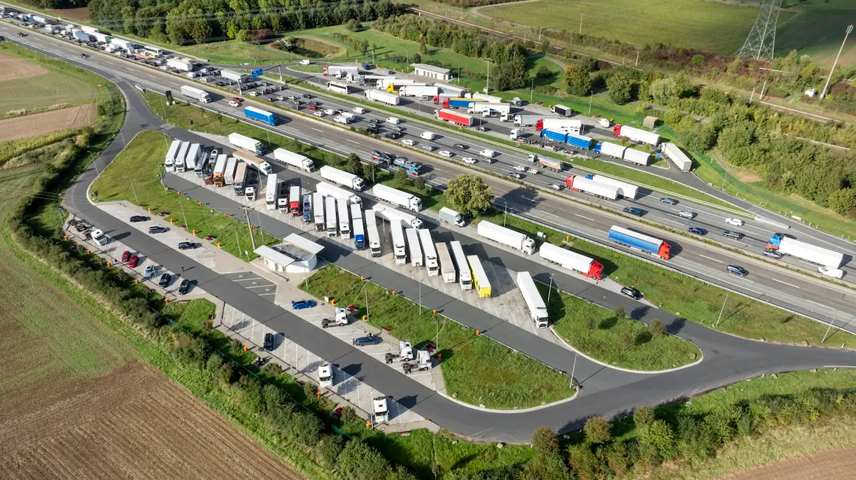 Voller Autobahn-Rastplatz von oben, sodass man vor allem die geparkten Lkws gut erkennen kann