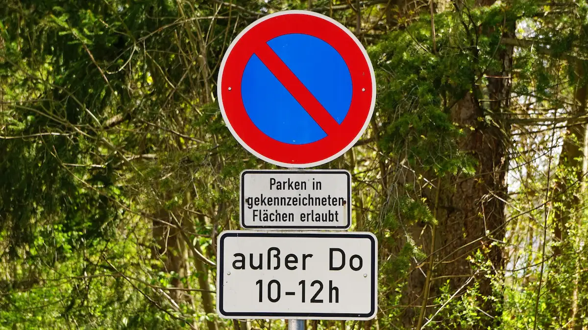 Beschilderung zeigt eingeschränktes Halteverbot an, darunter sind einige weiße Zusatzschilder zu sehen