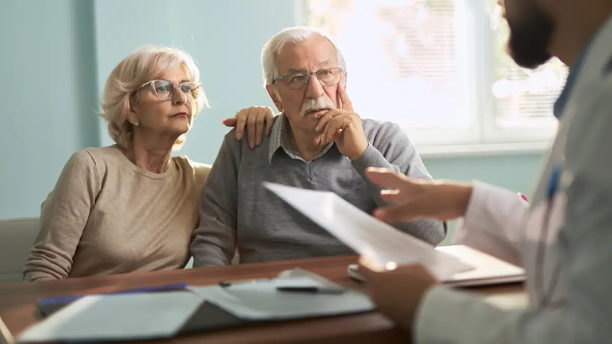 Alter: Älteres Ehepaar sitzt zusammen beim Arzt