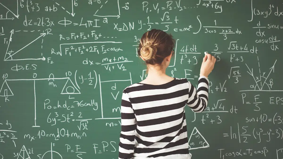 Mädchen löst Matheaufgabe an der Tafel